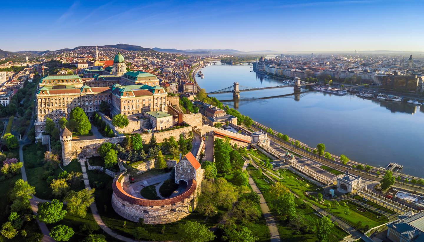 City Highlight: Budapest - Aerial panoramic skyline view of Buda Castle Royal Palace with Szechenyi Chain Bridge, St.Stephen's Basilica, Hungarian Parliament and Matthias Church at sunrise with blue sky